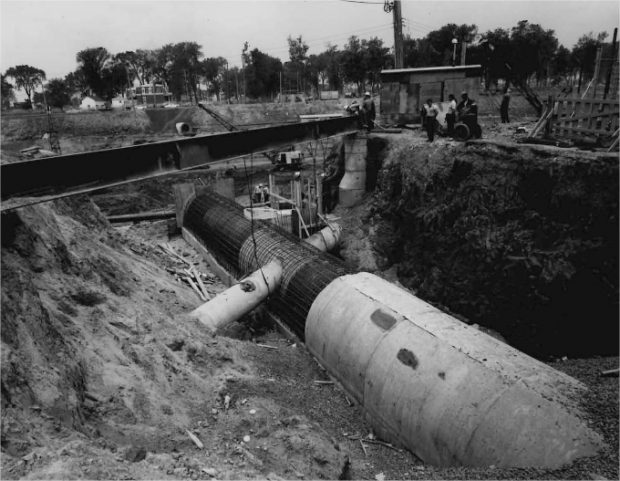 A sewer being dismantled in a trench with workers
