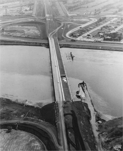 A bridge under construction with a small town in the background