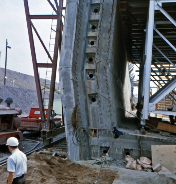 A structure under construction with a worker in the foreground