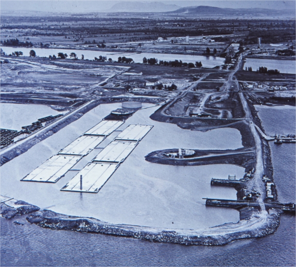 A dry dock with flooded structures and a mountain in the background