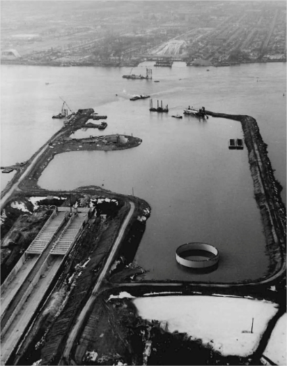 A dry dock under construction with a city in the background