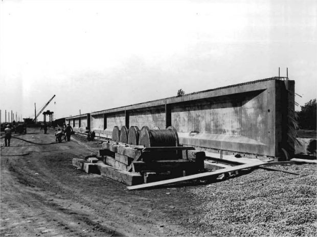 Concrete girders installed on the ground with workers