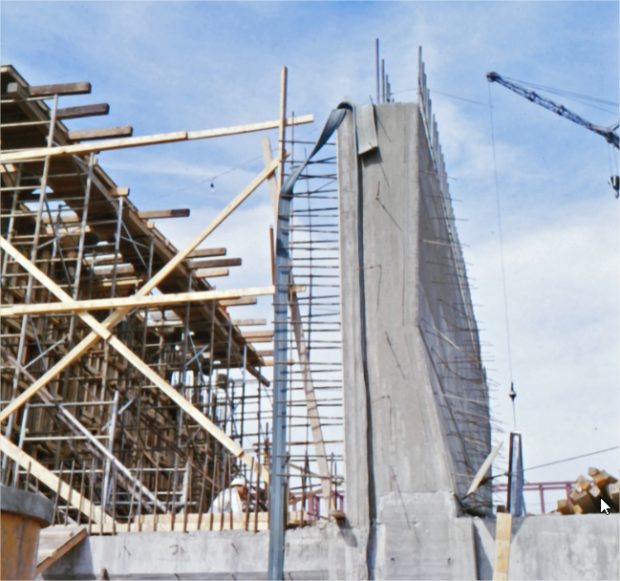 A concrete structure under construction with a crane