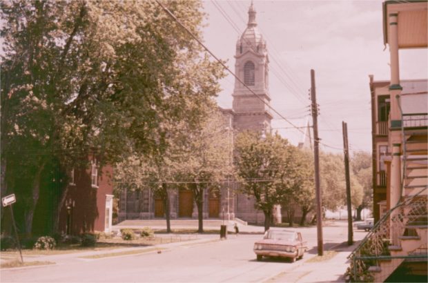 A church on a quiet street with a parked car