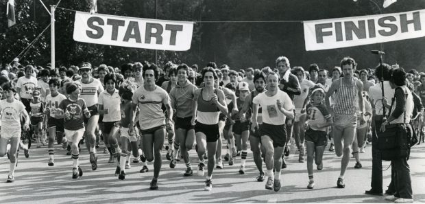 A large crowd runs towards a finish line