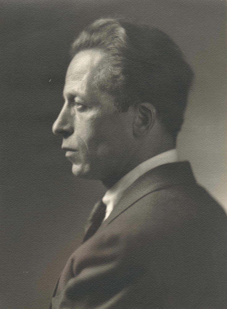 Black and white archival photo showing Albert Gilles in profile, dressed in a suit and tie, looking to the left