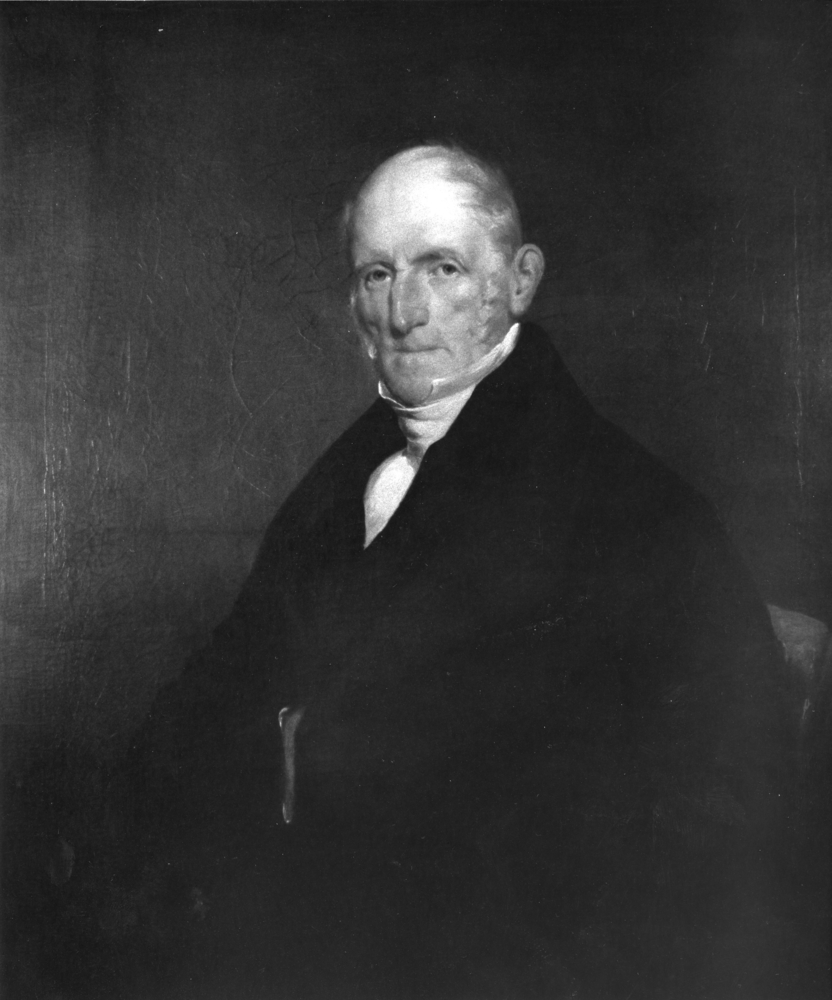 Black and white, three-quarter-view portrait photo of Peter Patterson. The elderly gentleman is wearing an elegant black frockcoat and white shirt.