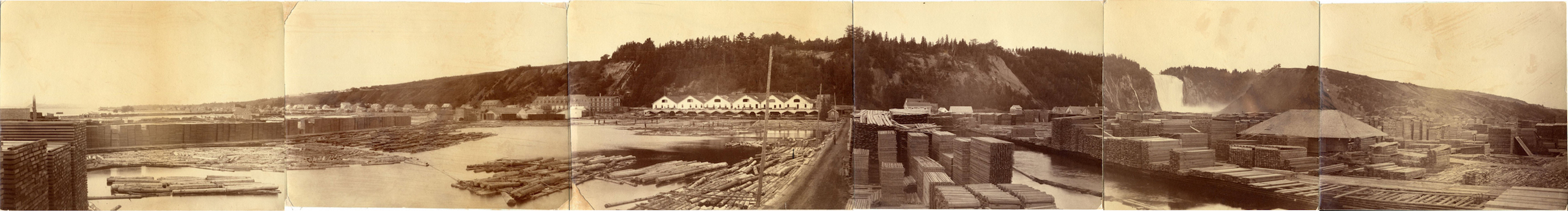 Sepia archival photos assembled to create a panoramic view. The first shot shows dozens of stacks of timber as well as logs floating in the pools at the foot of the Montmorency Falls just to the right, in the background. Several buildings can be seen at the base of the cliff.
