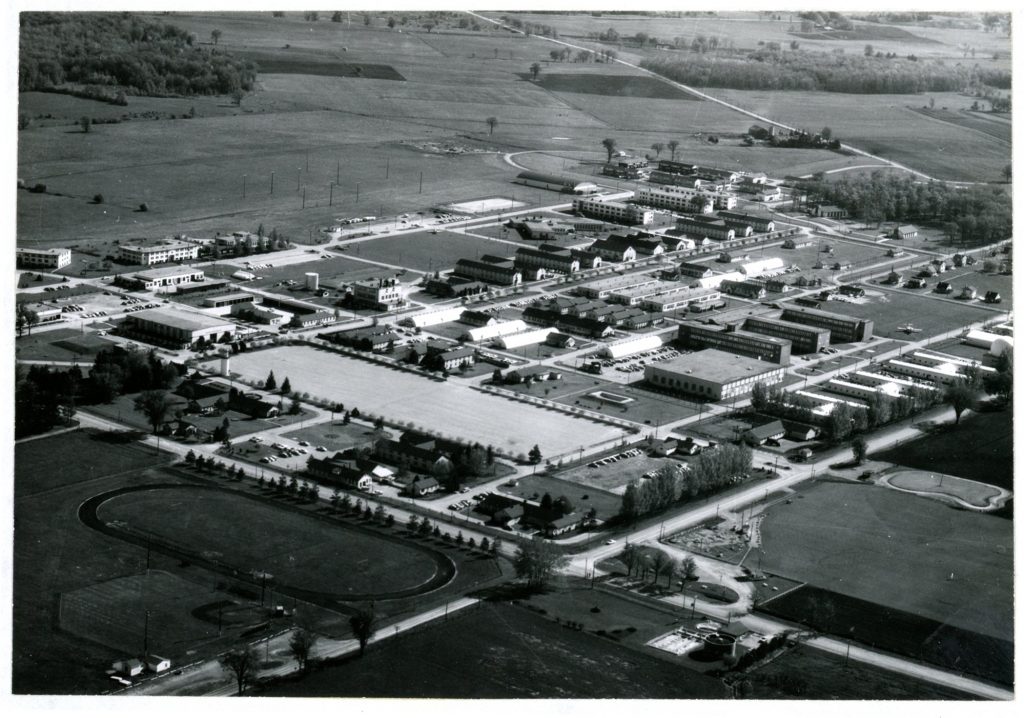 A black and white, birds-eye view of an Air Force base; farmer's fields in the distance.
