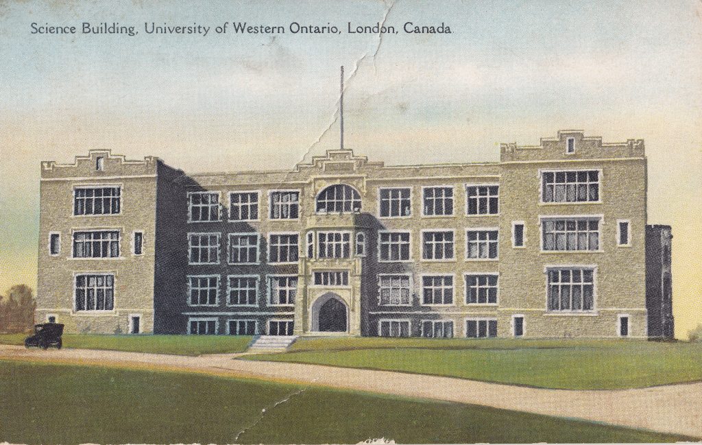 Carte postale en couleur d'un bâtiment universitaire de trois étages en briques grises. Une grande antenne est centrée sur le toit. L'étiquette en haut l'identifie comme étant l’édifice des Sciences, Université de Western Ontario, London, Canada.