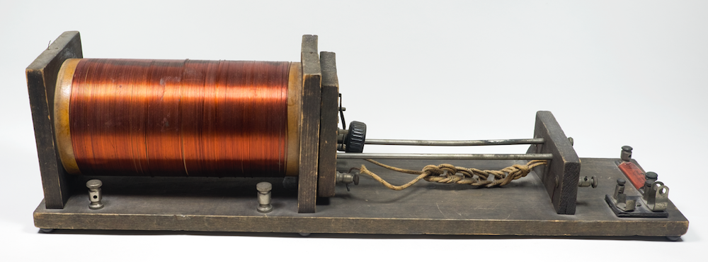 The loose coupler has a copper wire spool on the left, and attachments for connecting wires in front and on the right of the spool.