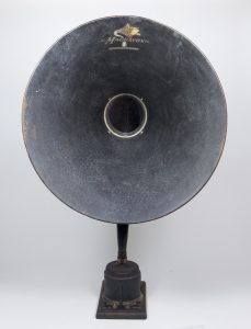 The large speaker horn, as seen from the front, is attached to a small but heavy, square metal base.