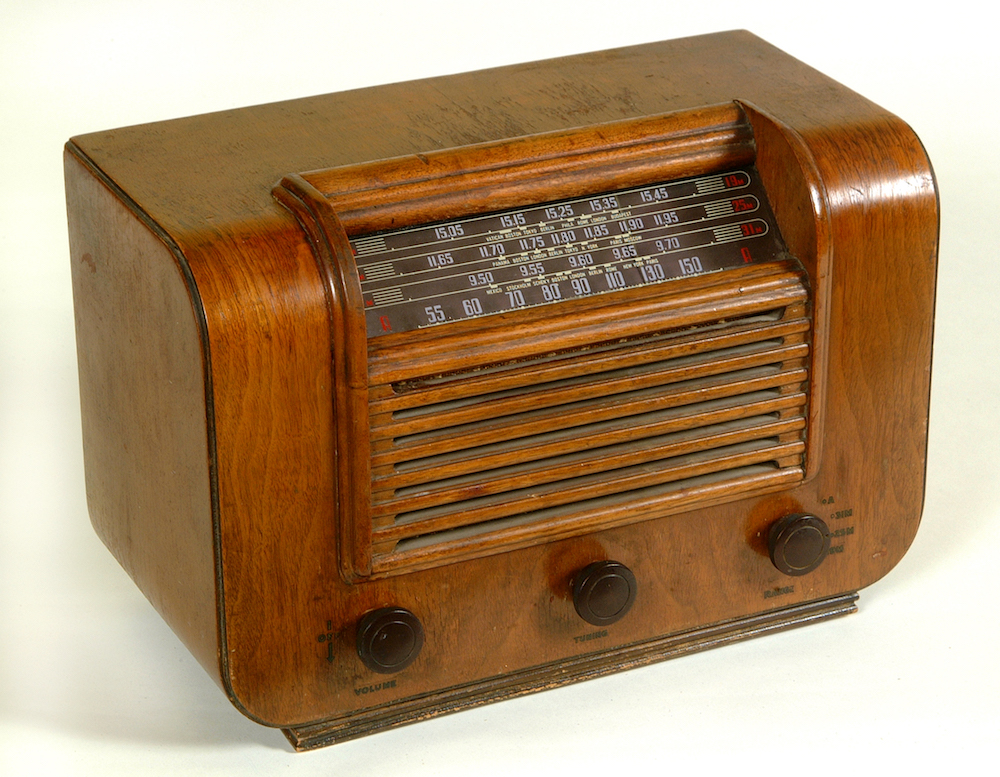 La radio est logée dans un meuble en bois avec un cadran à angle de 45 degrés sur le bord supérieur.