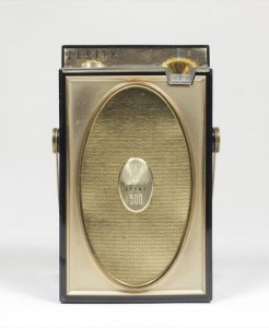 The small and vertically oriented radio has the body made of metallic plastic.
