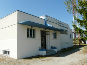 La structure blanche d'un étage aux accents bleus par une journée ensoleillée affiche sa façade décorée et son côté simple.