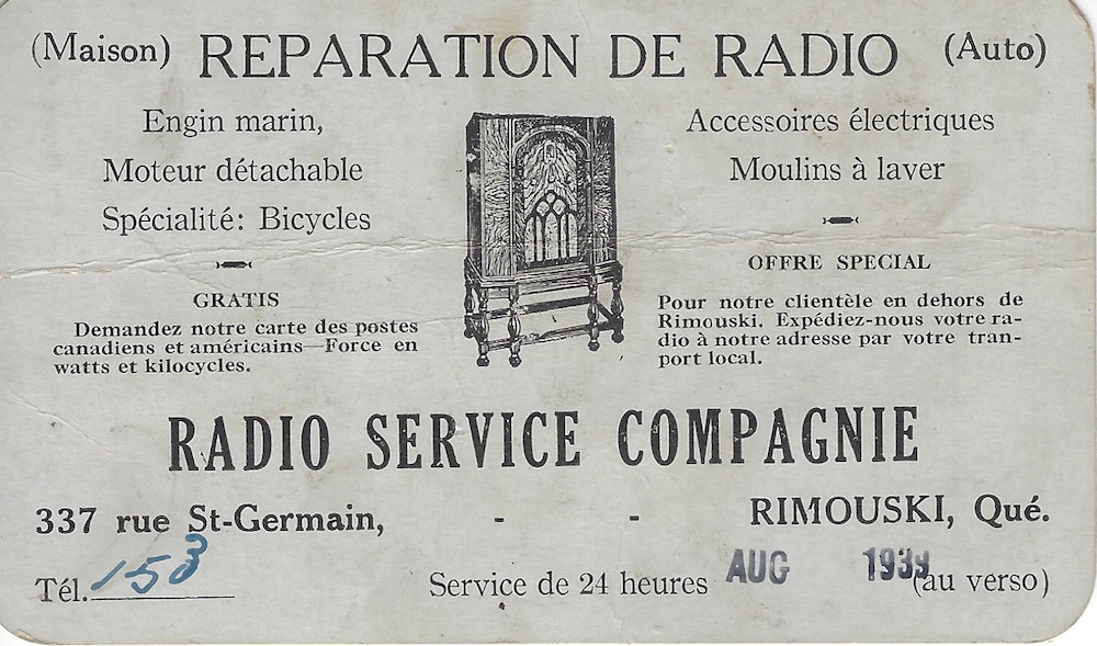 Une petite carte en papier rigide gris et noir avec un texte et un dessin au centre d'un meuble façon radio. Le texte est en français.