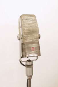 Le microphone est photographié sous une vue légèrement diagonale, montrant la face avant carrée et le côté en forme de trapèze.