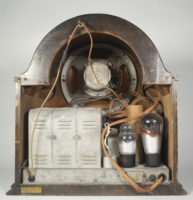 Look into the open back of a DeForest-Crosley radio displaying the tubes, transformer and loudspeaker.