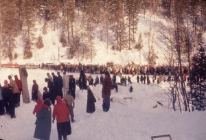 Colour photograph of a crowd of spectators at the bottom of a ski run.