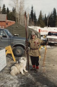Colour photograph of a man dressed as Olaus Jeldness and a dog in a parking lot.