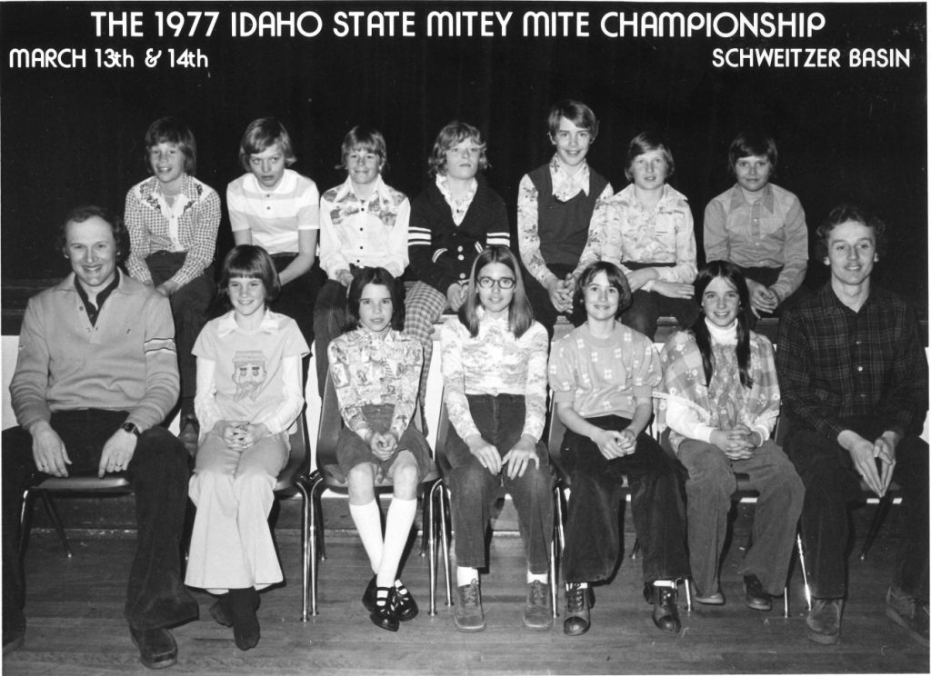 Black and white photograph of the 12 members of the 1977 Talent Squad ski team with their coaches.