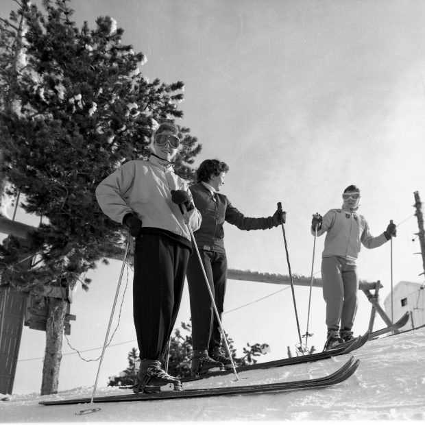 Black and white photo of three female ski racers in the 1950s.