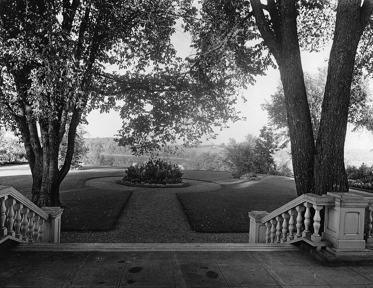 Black and white photograph of a circular garden at the bottom of a stone staircase, near the Saint Francis River.
