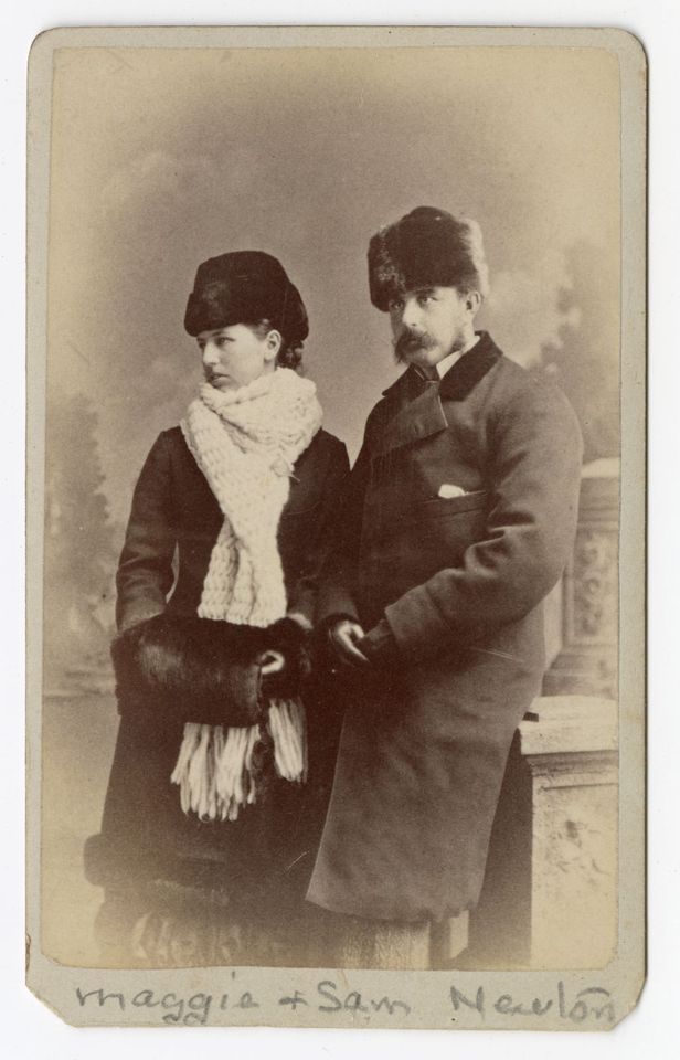 Black and white photograph of a woman and a man wearing coats and fur hats.