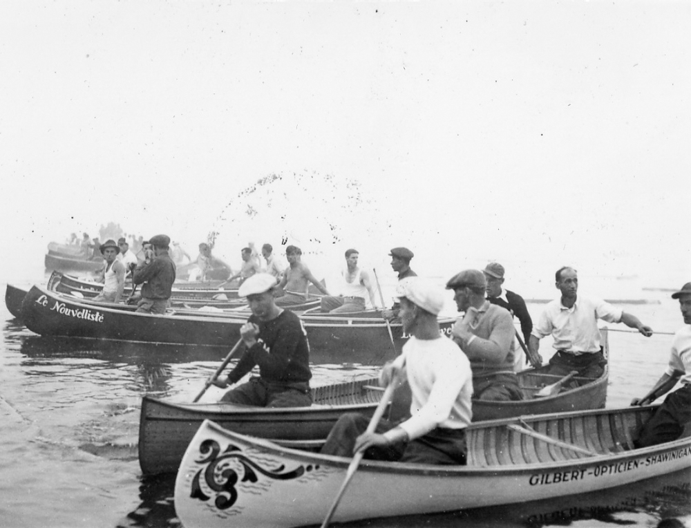 Teams of canoeists, including Le Nouvelliste’s team, line up their wooden canoes on the starting line.