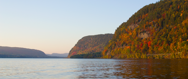 The Saint-Maurice River flows between high cliffs covered with autumn-coloured trees