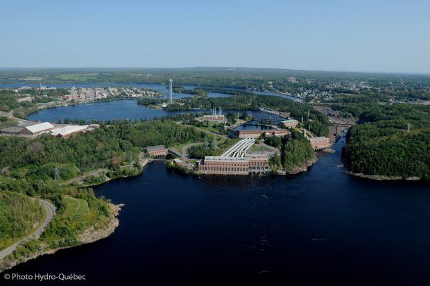 Aerial view of Shawinigan that shows the bay, the falls and three hydro-electric power plants. In the distance is the city centre and the Cité de l’énergie tower that stands on an island in the middle of the river.