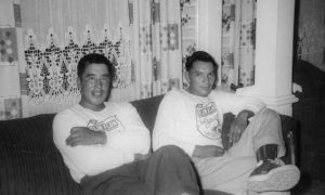 Two Indigenous men are sitting on a couch. 