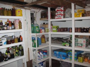 The interior of a walk-in cool room with shelves stocked with various items.