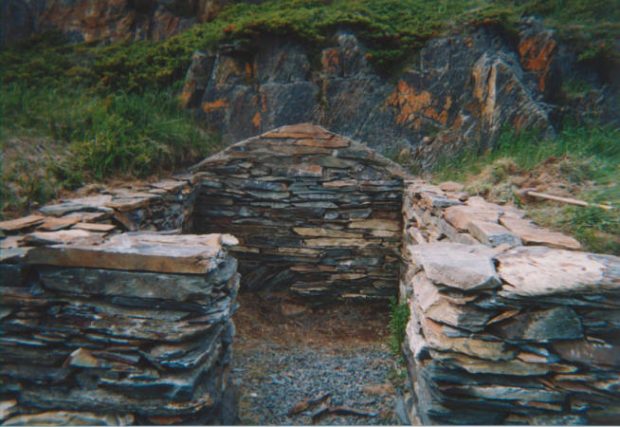 Front on view of stacked stone foundations of a hillside cellar.