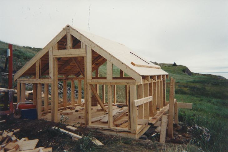 Exterior of the root cellar top shed being constructed with wood.