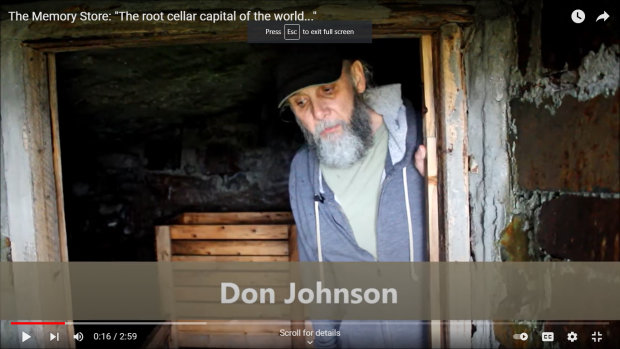Bearded middle-aged man with cap standing in the open door of a root cellar.