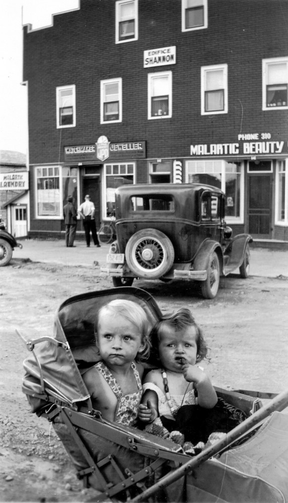 Two children in a stroller in front of the Shannon building in the 1940s