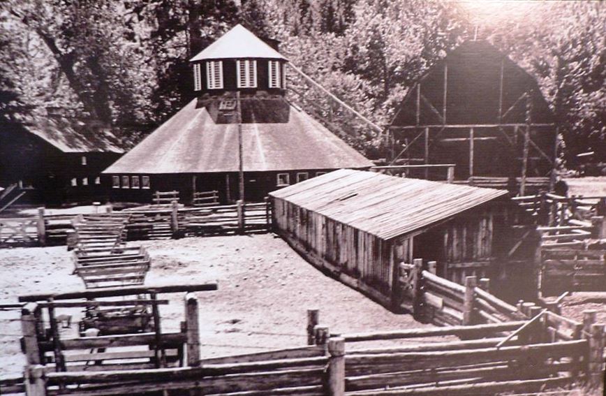 Sepia photo of two barns, outbuilding and cattle shed with fenced corral