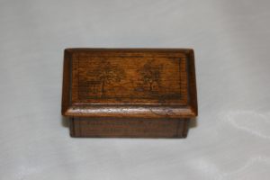 Small rebellion box mad by John David Willson for his son, Job Willson. The box has a sliding lid engraved with a picture of a small house with several trees. The sides of the box read "Lount and Matthews executed April 12, 1838" and "Job Willson from his father in prison"