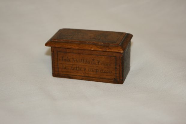 Small rebellion box mad by John David Willson for his son, Job Willson. The box has a sliding lid engraved with a picture of a small house with several trees. The sides of the box read Lount and Matthews executed April 12, 1838 and Job Willson from his father in prison