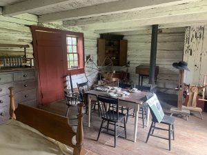 Single room log cabin with full bed, dinning and spinning artifacts.