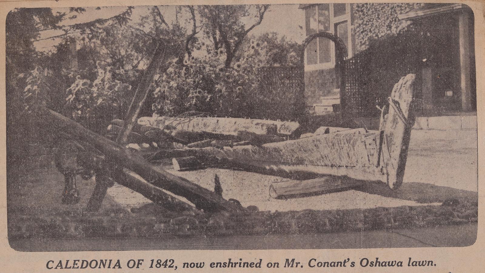 Newspaper clipping showing parts of a schooner on the lawn in front of a house.