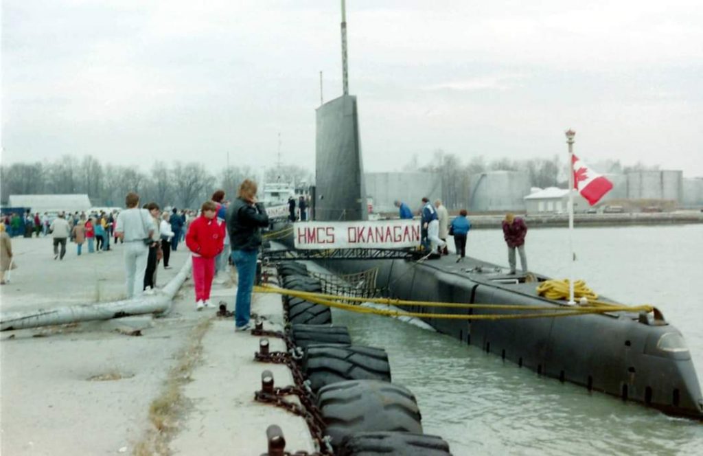 Colour photograph of a submarine docked at the harbour.
