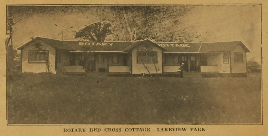 Sepia photograph from a newspaper of a small building. ‘Rotary Cottage’ is written on the roof in white. The caption reads ‘Rotary Red Cross Cottage Lakeview Park’.