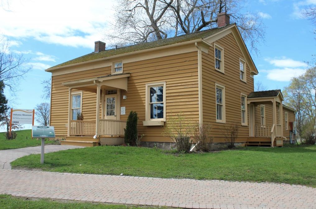 Colour photograph of a yellow wooden frame house.