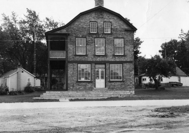 Black and white photograph of a two and a half storey brick building.