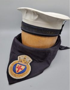 A colour photograph of two objects a cap and scarf from Sea Rangers.