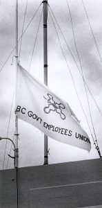 Un drapeau attaché à un mât arbore un logo et un texte qui lit « BC Gov’t Employees Union ». 