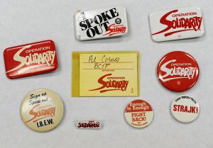 Une collection de macarons d’Operation Solidarity et une épinglette du syndicat polonais Solidarnosc. 