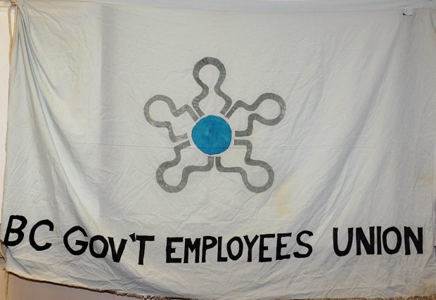 Photograph of a hand-painted flat reading “BC Government Employees’ Union” and the BCGEU logo.